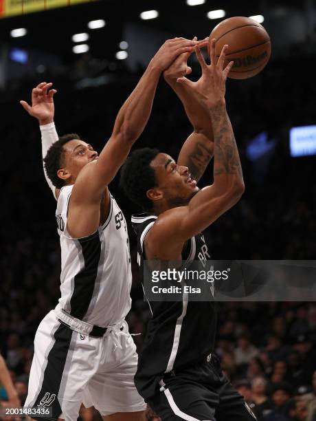 Nic Claxton of the Brooklyn Nets heads for the net as Keldon Johnson of the San Antonio Spurs defends at Barclays Center on February 10, 2024 in the...
