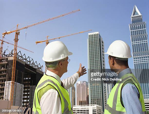 two male construction workers wearing hard hats, outdoors, rear view - construction worker office people stock pictures, royalty-free photos & images