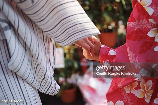 mother walking with daughter (5-7), close-up of hands - kazuko kimizuka ストックフォトと画像