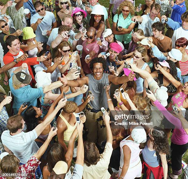 crowd of young adults taking photos of man with mobile phones - reputation ストックフォトと画像