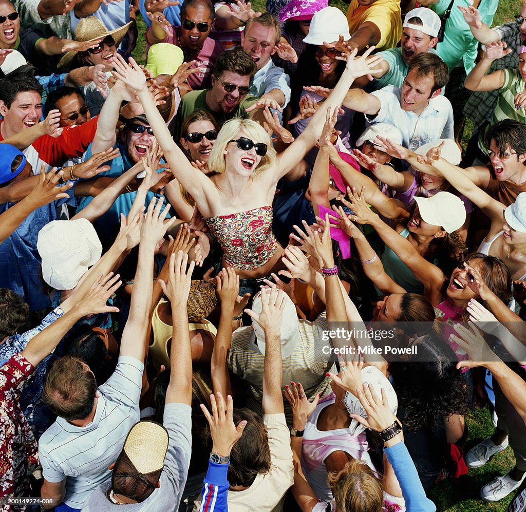 Young adults reaching for female celebrity, elevated view