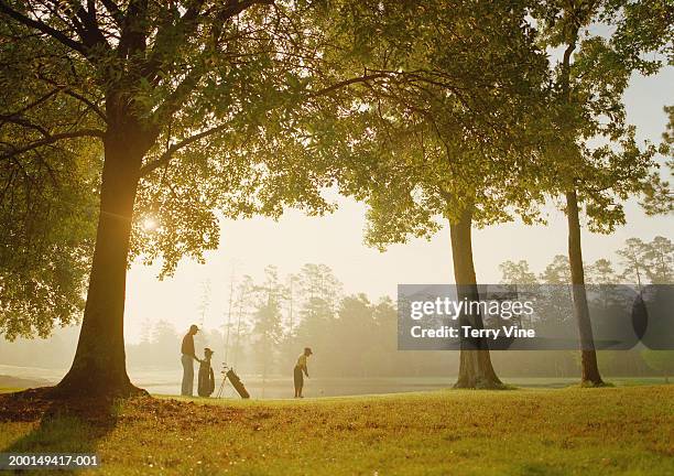 father and son (10-12) playing golf - father son golf stock pictures, royalty-free photos & images