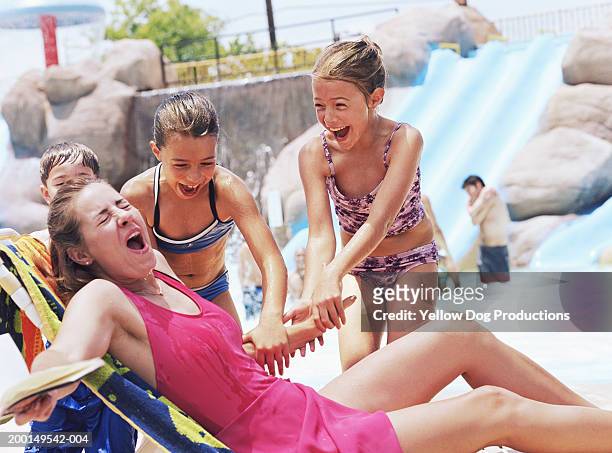 mother with children (8-10) near swimming pool smiling - naughty daughter stock-fotos und bilder