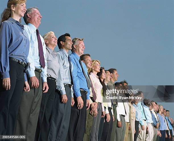 line of business people smiling, looking outward, low angle - group of businesspeople standing low angle view stock pictures, royalty-free photos & images