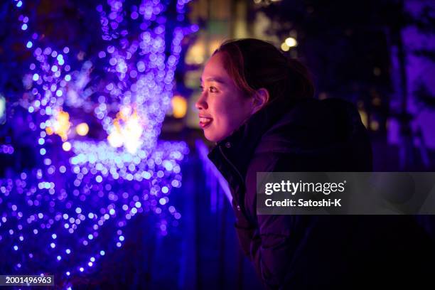 female athlete looking at christmas lights at night - royal blue stock pictures, royalty-free photos & images