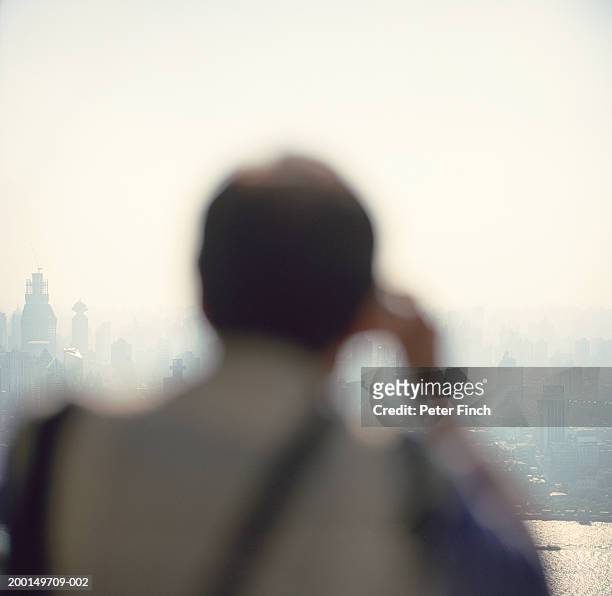 china, shanghai, man taking photograph (focus on city) - stoneplus5 stock-fotos und bilder