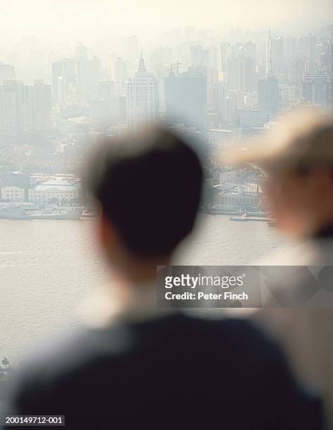 china, shanghai, two people in foreground (focus on city) - stoneplus5 stock-fotos und bilder