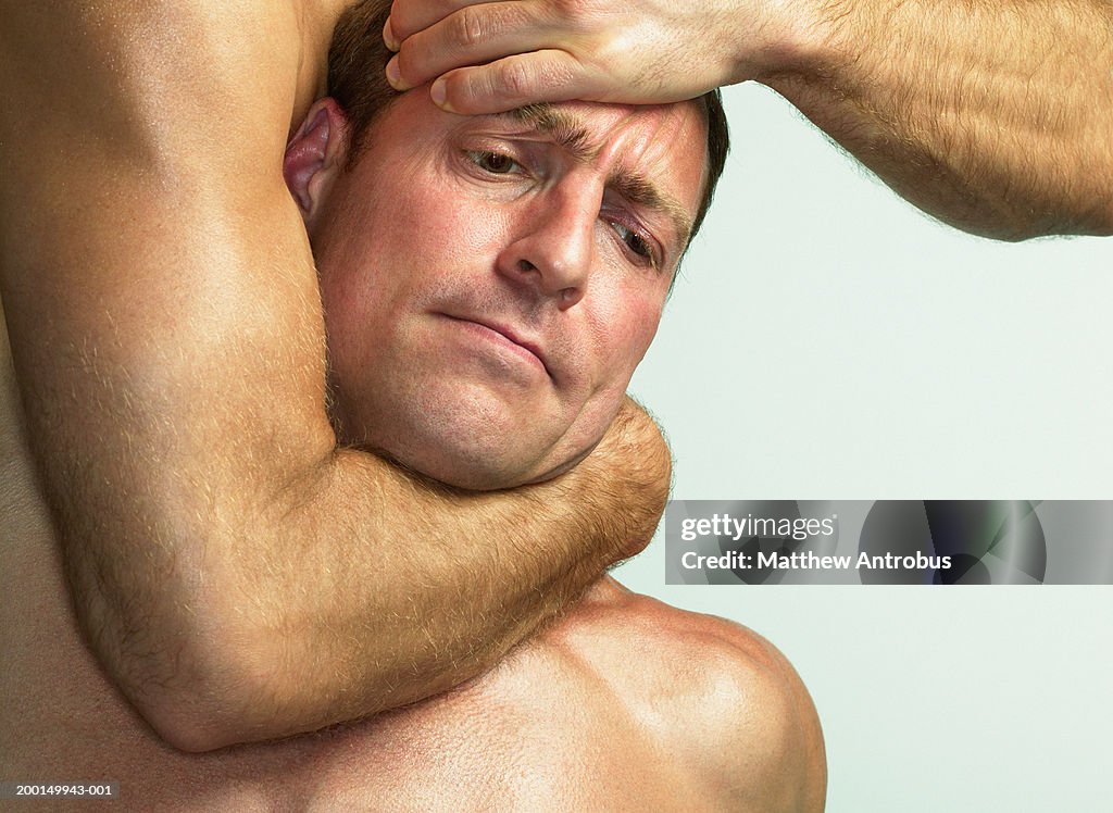 Two men wrestling, one in headlock, close-up