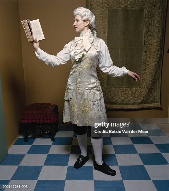 woman in male costume from regency era, holding book - historical reenactment stock-fotos und bilder