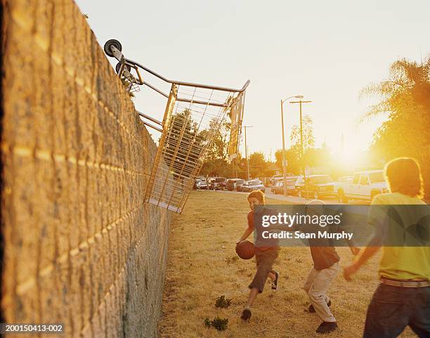 teenage boys (13-15) playing basketball, using grocery cart for hoop - kid basketball dunking stock pictures, royalty-free photos & images