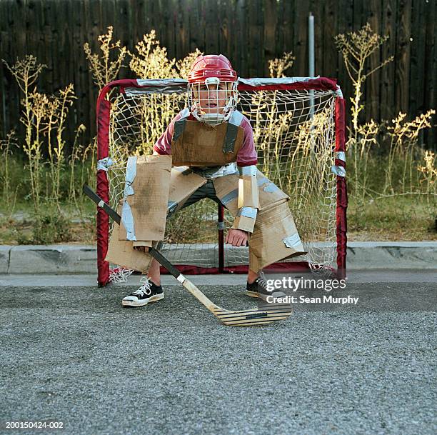 teenage boy (13-15) in cardboard, blocking goal in street hockey game - resourceful bildbanksfoton och bilder