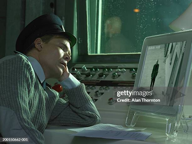 security guard asleep in front of monitor displaying man - man sleeping with cap stock pictures, royalty-free photos & images