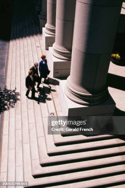 three businesspeople walking up steps of courthouse, elevated view - courthouse foto e immagini stock