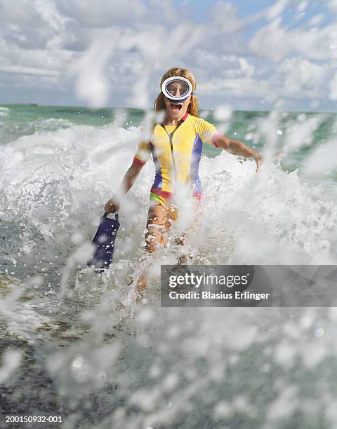 teenage girl (12-14) in scuba gear running through surf - scuba diving girl stockfoto's en -beelden