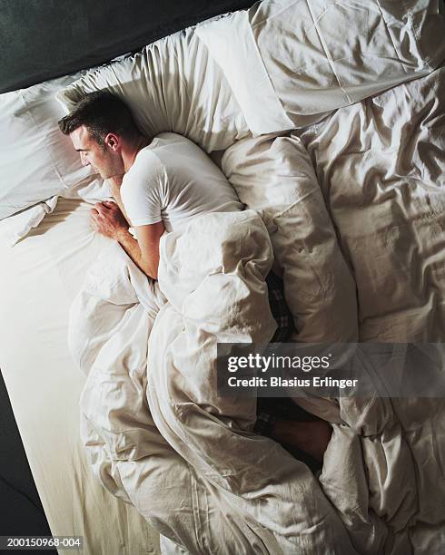 man sleeping on bed, elevated view - acostado de lado fotografías e imágenes de stock