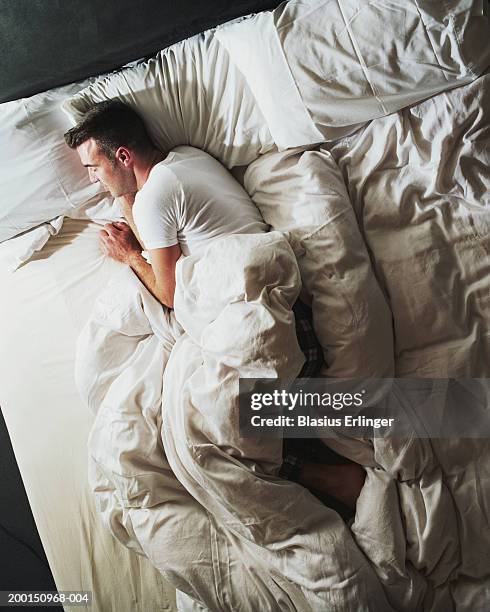 man sleeping on bed, elevated view - above view of man sleeping on bed stock pictures, royalty-free photos & images