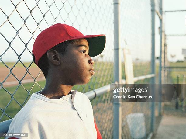 little league player leaning against fence - kid leaning stock pictures, royalty-free photos & images