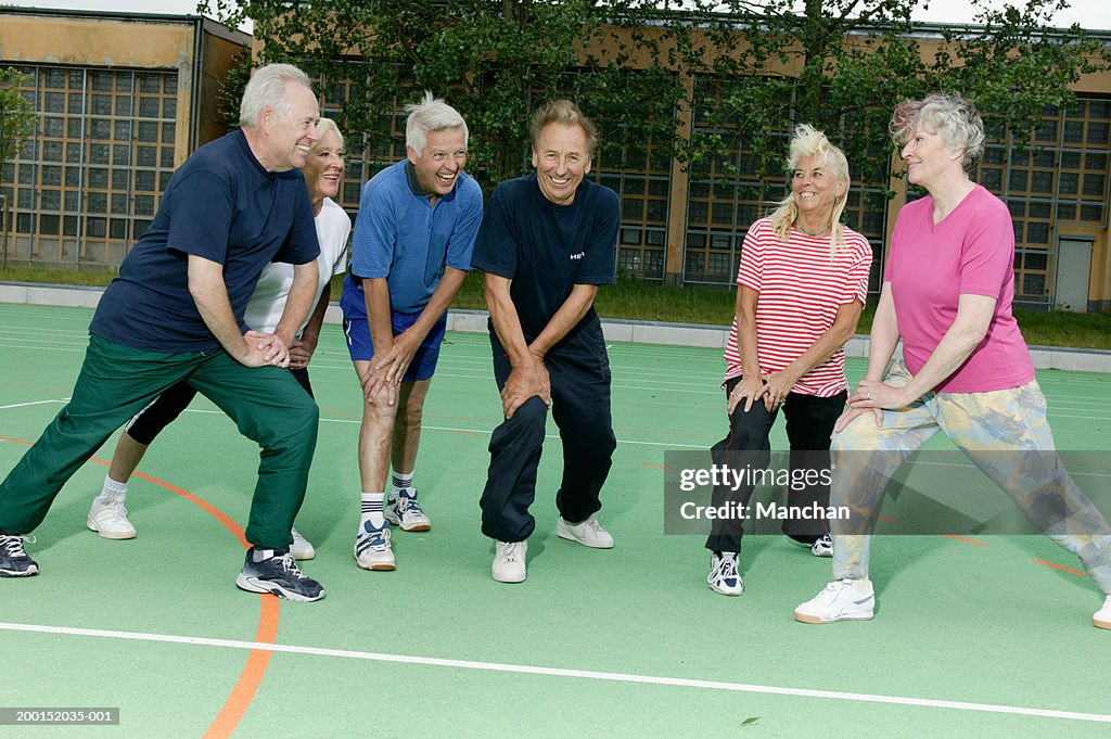 Group of senior people stretching outdoors, wearing sports clothes