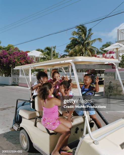 group of girls (10-12) with hands in air in golf cart, smiling - harbor island bahamas stock pictures, royalty-free photos & images