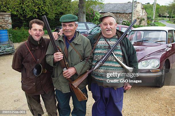 three mature men standing outdoors, with rifles and horns, portrait - hunter brown stock pictures, royalty-free photos & images