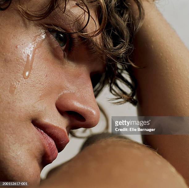 young man crying, head in hand, close-up - huilen stockfoto's en -beelden