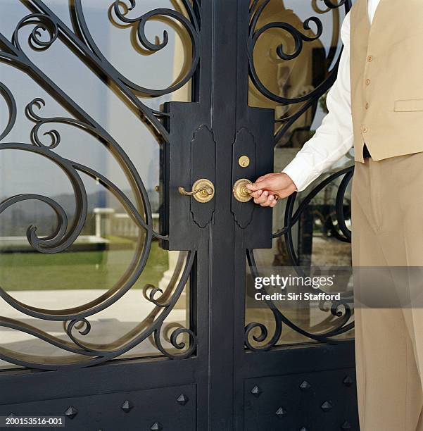 hotel attendant opening door (mid section) - door attendant imagens e fotografias de stock