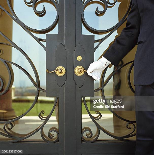 hotel attendant opening door (mid section) - white glove stock-fotos und bilder