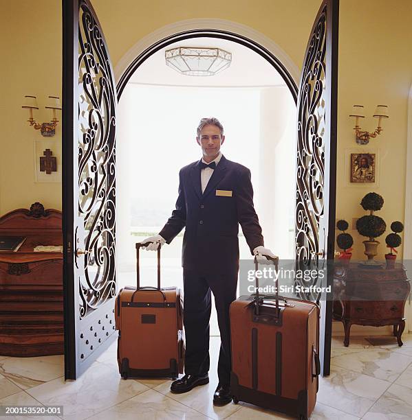 hotel attendant carrying luggage, portrait - doorman stockfoto's en -beelden