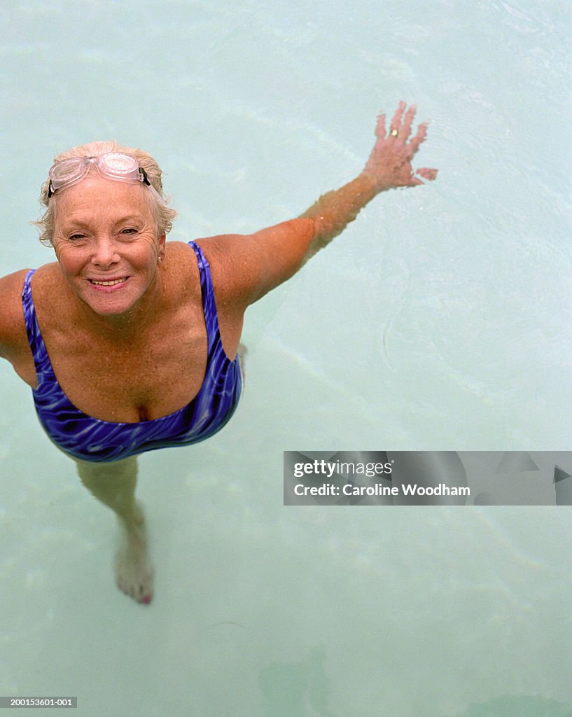 Senior woman in swimming pool, elevated view, portrait