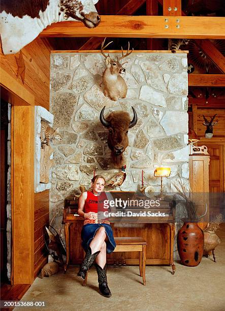 teenage girl (16-18) sitting on bench in front of piano, portrait - hunting trophy stock-fotos und bilder