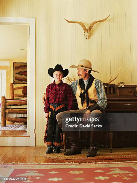 father and son (7-9) wearing cowboy clothing in living room - lenço do pescoço imagens e fotografias de stock