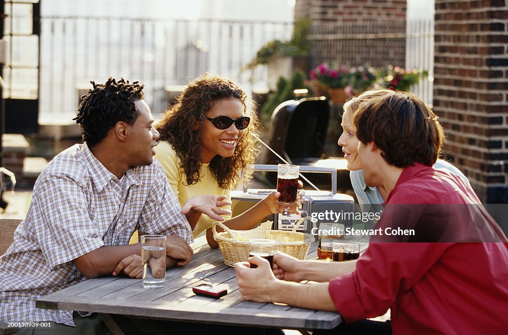 Group of friends sitting at picnic bench, talking