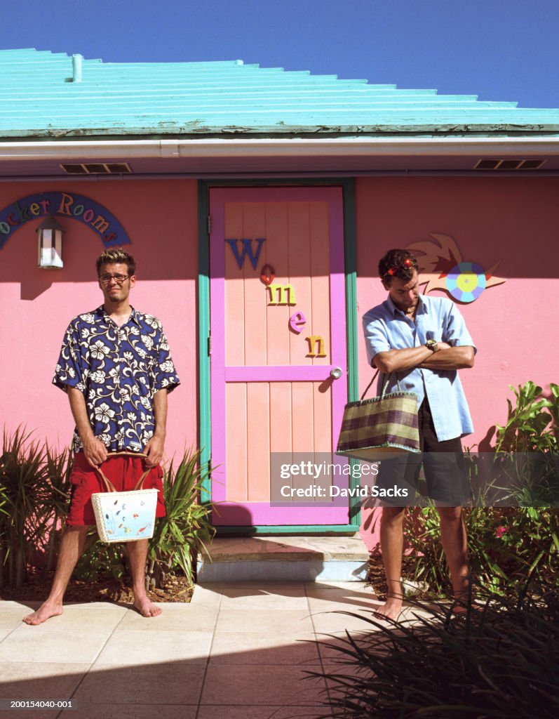 Two men waiting in front of women's locker room