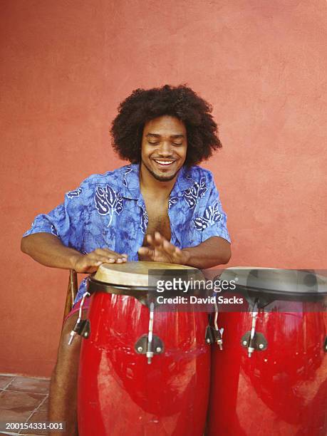 man playing drums, smiling - ボンゴ ストックフォトと画像