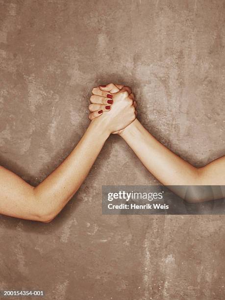 two women grasping hands, close-up - contact color background photos et images de collection