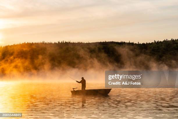 a senior man fishing at sunrise. - visindustrie stockfoto's en -beelden