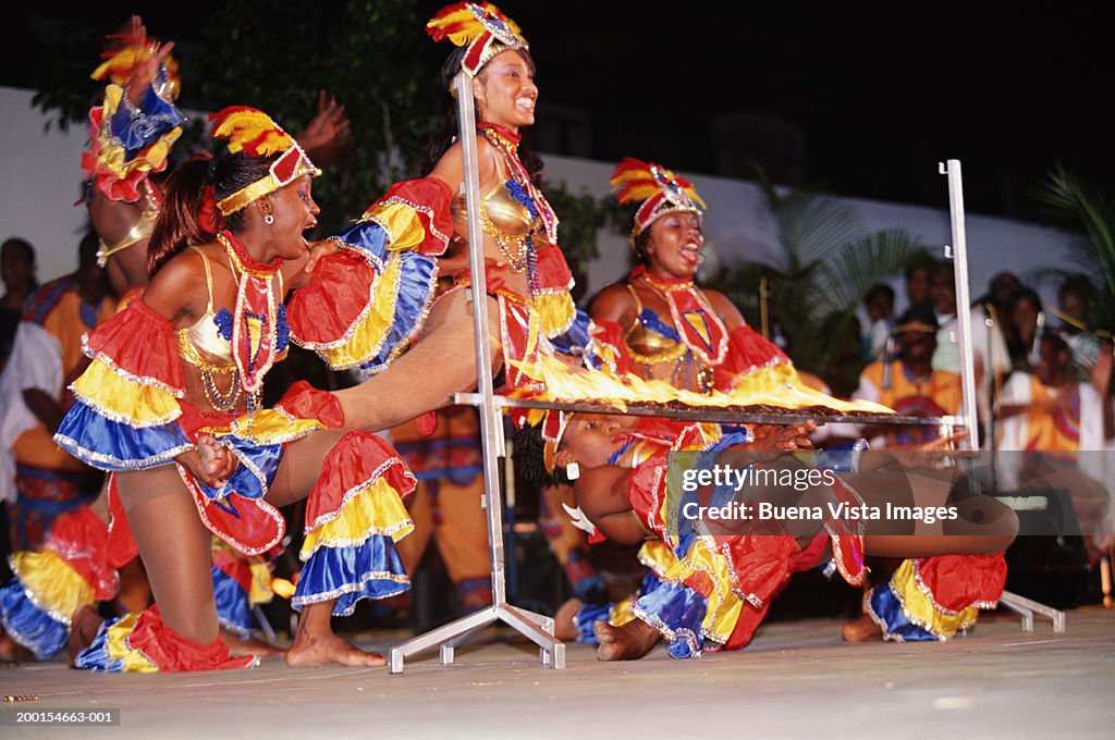 Group of women in carnival costumes doing limbo dance