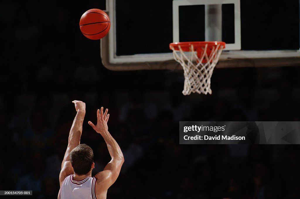 Basketball player shooting from free throw line, rear view