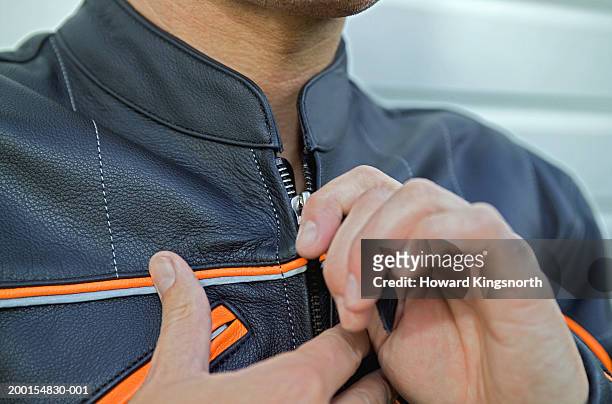 man zipping up leather jacket, close-up - zipper stock pictures, royalty-free photos & images