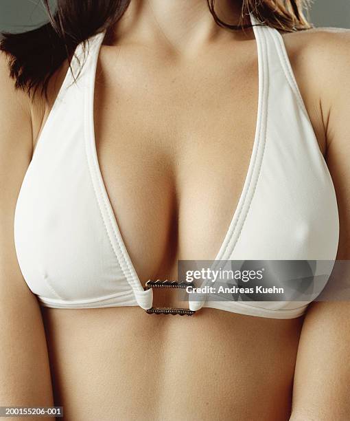 young woman wearing white bikini top, mid section, close-up - decolleté stockfoto's en -beelden