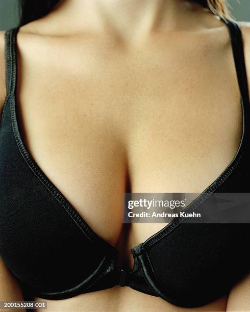 young woman wearing black bra, mid section, close-up - decolleté stockfoto's en -beelden