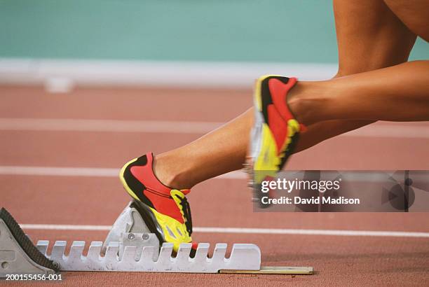 track sprinter taking off from starting block, low section - yellow shoe stock pictures, royalty-free photos & images