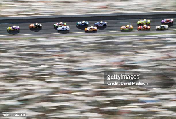 stock cars racing around track (blurred motion, digital enhancement) - nascar stock pictures, royalty-free photos & images
