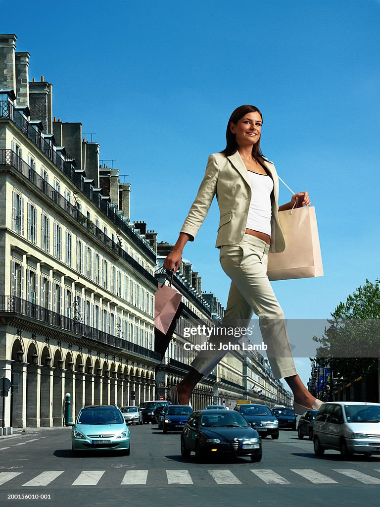 Giant woman with shopping bags crossing busy road (Digital Composite)