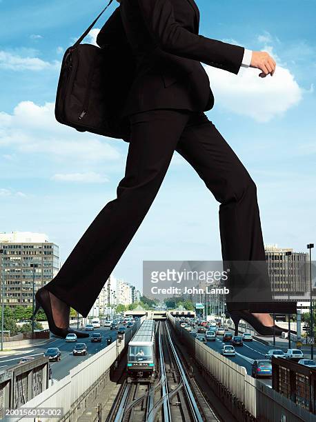 giant woman stepping over train on tracks (digital composite) - beenden stockfoto's en -beelden
