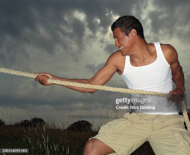 Man Pulling On Rope In Field Under Cloudy Sky High-Res Stock Photo - Getty  Images