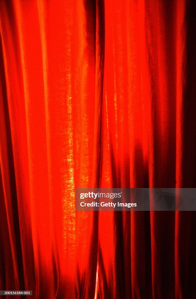 Light shining through red theatre curtains, full frame