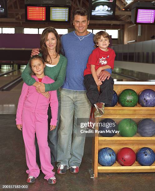 paar mit zwei kinder (3 bis 8) in bowlingbahn, lächeln, portra - family bowling stock-fotos und bilder