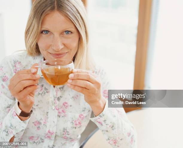 mature woman drinking tea, smiling, portrait - david swallow stock pictures, royalty-free photos & images