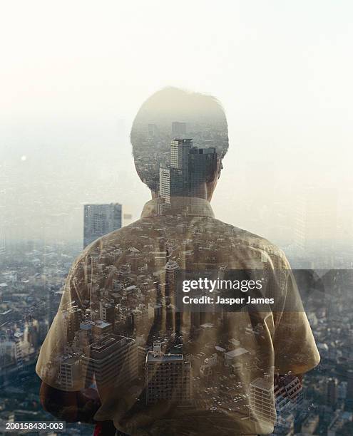 man at window overlooking cityscape, rear view (multiple exposure) - stoneplus8 stock pictures, royalty-free photos & images